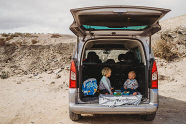 Kinder machen ein Picknick im Kofferraum ihres Autos in den Ferien - CAVF80992