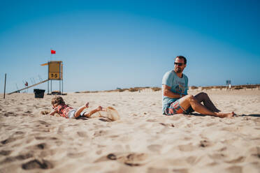 Father and child playing a the beach on a sunny day - CAVF81000