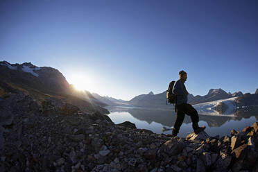 Man hiking at a fjord in eastern Greenland - CAVF81041