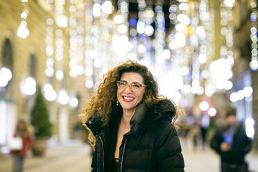 A woman dressed to go out for the evening, smiling on a street in Florence. - CUF55221