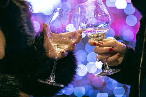 Zwei Frauen stoßen in einer Bar in Florenz mit Weingläsern an. - CUF55223
