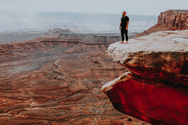 Man standing on the edge of a large cliff with open views - CAVF81049