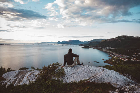 Man sitting on a rock looking at sea view - CAVF81074