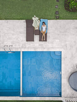 Aerial view of attractive woman near the pool at resort - CAVF81141