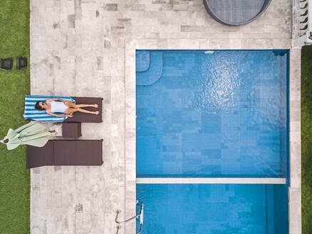 Aerial view of attractive woman near the pool at resort - CAVF81142