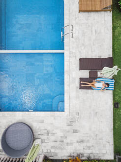 Aerial view of attractive woman near the pool at resort - CAVF81143