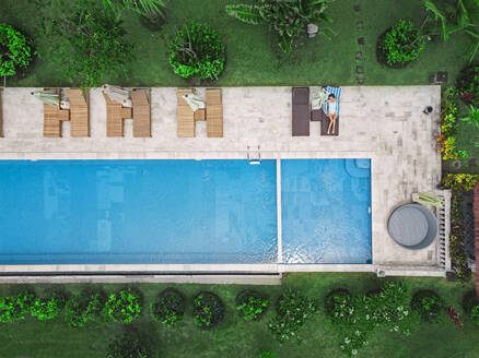 Aerial view of attractive woman near the pool at resort - CAVF81146