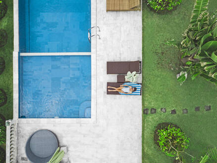 Aerial view of attractive woman near the pool at resort - CAVF81148