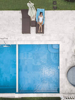 Aerial view of attractive woman near the pool at resort - CAVF81149