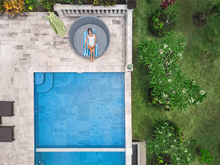 Aerial view of attractive woman near the pool at resort - CAVF81150