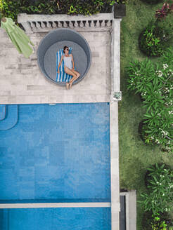 Aerial view of attractive woman near the pool at resort - CAVF81151
