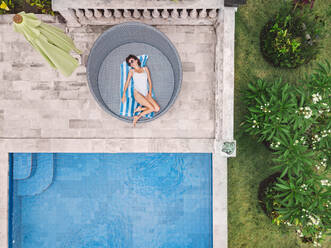 Luftaufnahme einer attraktiven Frau in der Nähe des Pools im Resort - CAVF81153
