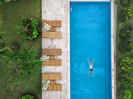 Aerial view of attractive woman floating over water at resort - CAVF81155