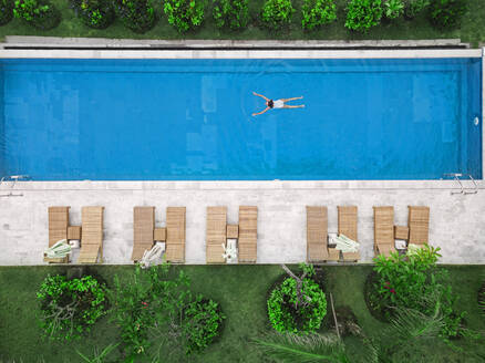 Aerial view of attractive woman floating over water at resort - CAVF81157