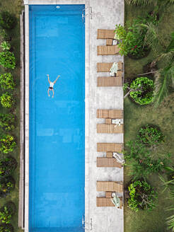 Aerial view of attractive woman floating over water at resort - CAVF81162