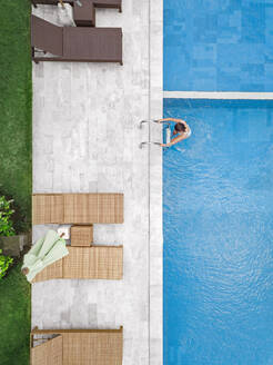 Aerial view of attractive woman near the pool at resort - CAVF81163