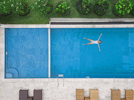 Aerial view of attractive woman floating over water at resort - CAVF81165