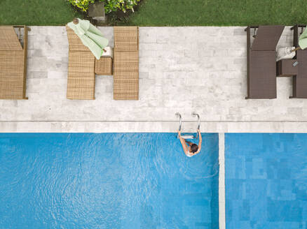 Aerial view of attractive woman near the pool at resort - CAVF81166
