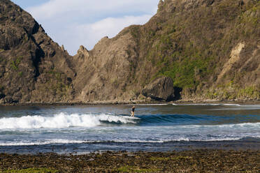 Female surfer on a wave, Sumbawa, Indonesia - CAVF81171