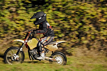 12 Jahre alter Junge fährt mit seinem Motocross-Motorrad durch ein Feld - CAVF81228