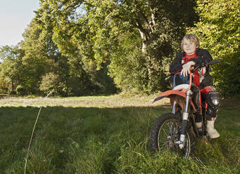 12-jähriger Junge, der eine Pause auf seinem Geländemotorrad macht - CAVF81232