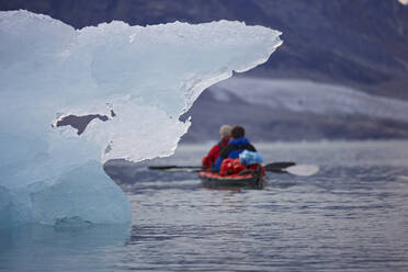 2 men traveling with a sea kayak in Eastern Greenland - CAVF81240