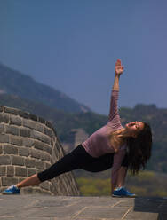 Frau übt Yoga an der Chinesischen Mauer - CAVF81272