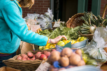 Junge Frau pflückt Gemüse auf dem Bauernmarkt - CAVF81306