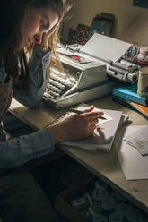 Junge Frau schreibt an einer Schreibmaschine im Büro - CAVF81309