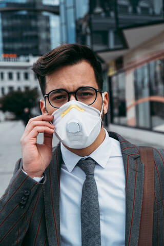 Business man standing on city street with protective face mask. stock photo