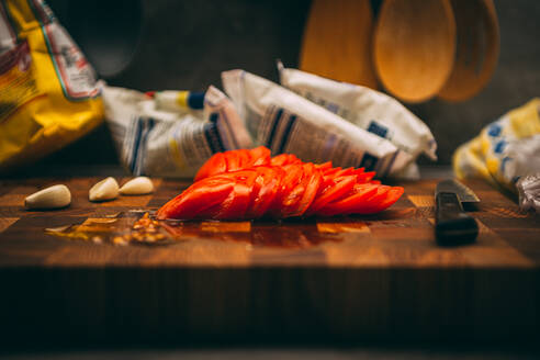 Kochen und Haus Konzept - Großaufnahme von männlichen Hand Schneiden von Tomaten auf Schneidebrett mit scharfen Messer - CAVF81389