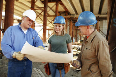 Group of construction workers looking over plans - CAVF81428