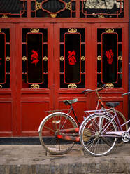 Fahrräder parken vor roten Türen in Pingyao - CAVF81471