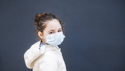 Girl with surgical mask in front of dark blue background - DGOF01003