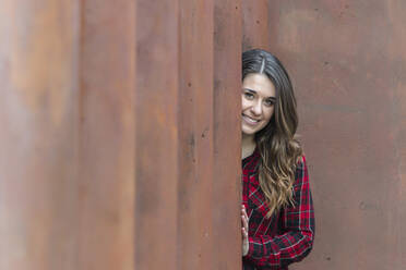 Portrait of smiling young woman wearing red plaid shirt - MTBF00407