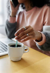 Close-up of young woman sitting at tablet working from home - MGOF04300