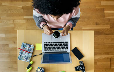 Top view of young woman working from home using laptop - MGOF04308