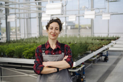 Portrait of confident woman in greenhouse of a gardening shop - JOSEF00664