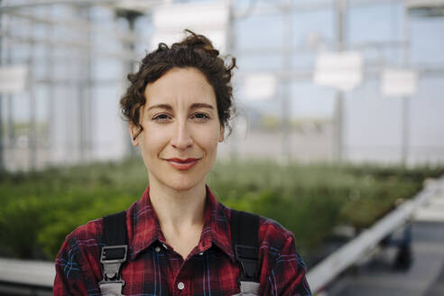 Portrait of confident woman in greenhouse of a gardening shop - JOSEF00666