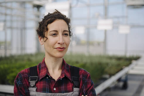 Portrait of woman in greenhouse of a gardening shop - JOSEF00667