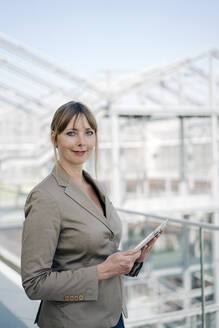 Portrait of a confident businesswoman holding tablet - JOSEF00704