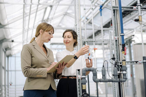 Two businesswomen with clipboard and model - JOSEF00716