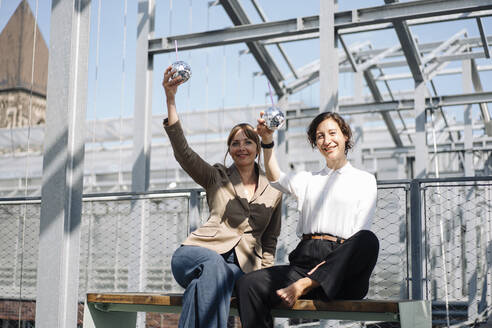 Two businesswomen having a break at a metal construction outdoors - JOSEF00737