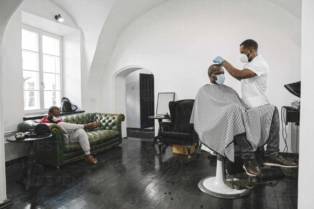 Barber Wearing Surgical Mask And Reusable Gloves Cutting Hair Of The Customer AHSF02534 
