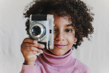 Porträt eines lächelnden kleinen Mädchens mit Vintage-Kamera - EBBF00092