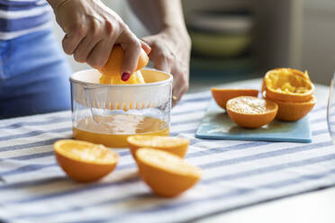 Woman sqeezing fresh orange juice - WPEF02897