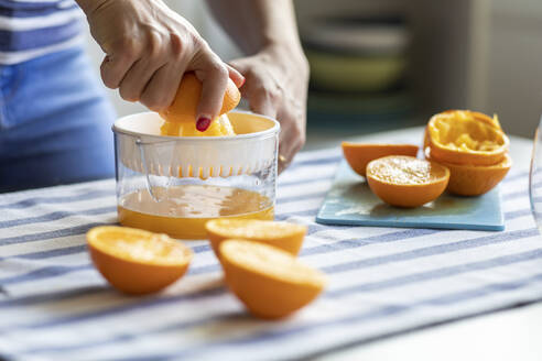 Frau, die frischen Orangensaft auspresst - WPEF02897