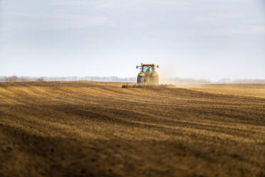 Landwirt im Traktor pflügt Feld im Frühling - NOF00087
