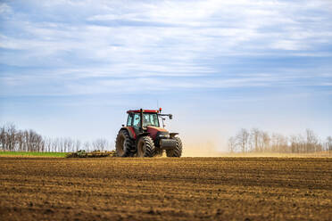 Landwirt im Traktor pflügt Feld im Frühling - NOF00088