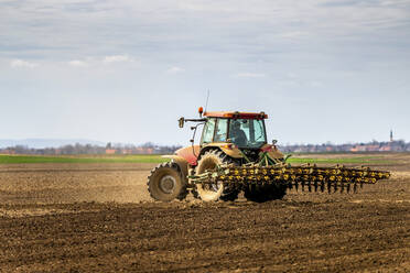 Landwirt im Traktor pflügt Feld im Frühling - NOF00090